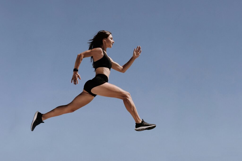 Athletic woman in motion leaping across the sky demonstrating energy and fitness outdoors.